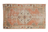 Distressed vintage Oushak rug with stepped medallion, dusty blush, ivory, mint green, and visible wear. 2'6