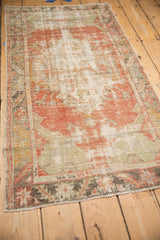 Longitudinal view of a distressed Oushak rug showing its even wear and faded medallion design.