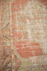 Distressed, low-pile texture of a vintage Oushak rug with soft blush and charcoal tones.
