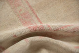 The even short pile and supple hand-knotted texture of a folded distressed Oushak carpet.