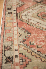 Vintage Oushak runner with distressed dusty rose and seafoam green patterns.