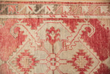 Worn low-pile texture and primitive blossom design on a vintage distressed Oushak rug.