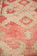 Low pile texture on a distressed Oushak rug showing blush motifs and visible knot heads.