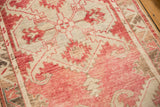 Abrashed blush field and low, worn pile of a vintage distressed Oushak rug runner.