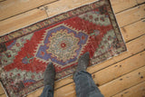 Looking down at the distressed texture and scale of a vintage Turkish Oushak runner mat.
