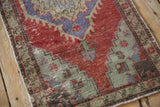 Meandering vine border and stepped spandrel on a vintage Oushak rug with time-softened wear.