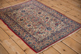 Angled perspective of a vintage Persian Isfahan rug highlighting its intricate floral field and short pile.