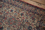 Angled view of a vintage Isfahan rug's corner, highlighting the dense pile and intricate floral border.