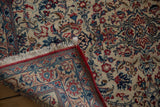 Intact red side cord selvage and short fringe on a corner of a vintage Persian Isfahan rug.