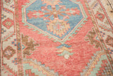 Close-up of serrated floral details within the blue hexagonal medallion of a distressed Oushak rug.