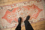 A view from above showing the scale and distressed texture of a madder red vintage Oushak rug runner.