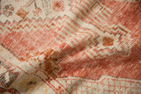 Soft, low pile and visible knot heads of a distressed Oushak rug in madder red and ivory.