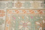 Geometric gul and meandering vine border in seafoam green, pale rust, and pops of magenta.