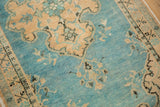 Vintage distressed Oushak rug with abrashed sky blue field, sand floral motifs, and even pile wear.