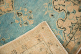 Vintage Oushak rug detail: sky blue floral pile, cream foundation, and intact side selvage.