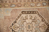 Distressed Oushak rug corner showing blue spandrel, sage floral motifs, and varied border design.