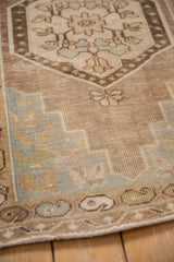 Distressed vintage Oushak rug's lower field with stepped spandrels and muted boteh border.