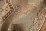 Distressed Oushak rug pile texture, subtle floral patterns, dusty mauve and pale sage green.