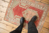 Overhead view of the distressed, low pile and even wear of a vintage Oushak prayer rug.