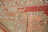 The woven foundation and distressed pile of a vintage Oushak rug's folded corner.