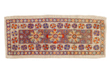 Distressed Oushak runner with aubergine floral medallion, ivory border, and colorful pinwheel motifs.