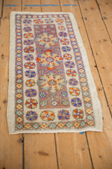 Distressed Oushak rug close-up: bursting floral blossoms, pinwheel petals, and worn pile.