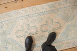 Distressed vintage Dosemealti rug with even wear, ivory field, and faded pale blue patterns.