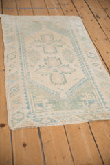 Distressed Dosemealti rug close-up showcasing muted ivory and pale blue geometric patterns.