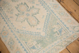 Distressed vintage Dosemealti rug featuring worn ivory and pale blue geometric designs.