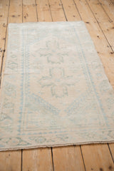 Close-up of the textured, distressed pile with faded ivory and pale blue geometric patterns.