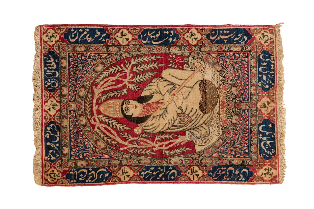 Antique pictorial Kerman rug with a royalty cameo medallion, cochineal red field, and navy calligraphic border.