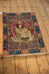 Angled view of the entire antique pictorial Kerman rug with its central royalty scene.