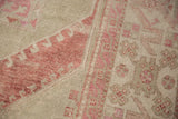 Distressed Turkish Oushak carpet showing even wear to the knot heads in dusty burgundy and ivory.