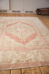 Long view of the vintage distressed Oushak carpet highlighting its low pile and faded pattern.
