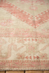 Detailed view of the vintage Oushak's low pile showing even wear to the knot heads.