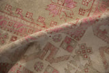 A soft fold in the distressed vintage rug reveals its low pile and hand-knotted texture.