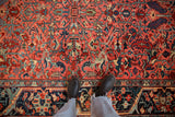 Personal perspective showing the gem-toned geometric pattern on a vintage Heriz rug.