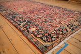 Angled view of a vintage Heriz rug's navy border with intricate palmettes and blush field.