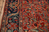 Navy blue border with arabesques next to the brick red geometric field on a vintage Heriz rug.