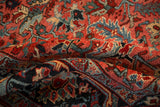 Rich gem-toned colors and geometric arabesques on the textured pile of a vintage Heriz.