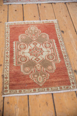 Vintage distressed Oushak rug mat with rust, brown, ivory medallion, and textured wear.