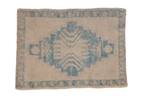 Distressed Turkish Oushak rug with a stepped geometric medallion in sky blue over a beige field.
