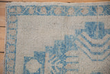 Worn, hand-knotted pile and sky blue meandering vine border of a vintage Oushak rug.