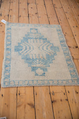 Angled corner view of a distressed Oushak rug showing the textured, low pile.