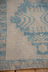 Evenly worn pile showing the knot heads on a distressed sky blue and ivory Oushak rug.