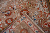 Distressed Oushak rug with camel, red field; folded corner reveals Chintamani border.