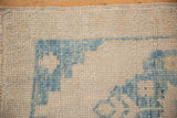 Evenly worn, textured knot heads form a sky blue stepped pattern on this ivory Oushak rug corner.