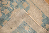 Reverse of the distressed Oushak rug showing the tidy, hand-knotted foundation and secured side cord.