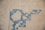 The cobalt blue corner spandrel of a distressed Oushak carpet showing low-pile and even wear.