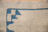 Oushak rug corner detail, cobalt blue serrated design on ivory pile with even wear.